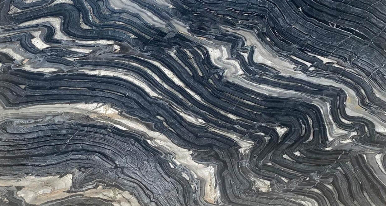 Gri ve beyaz tonların dalgalı desenlerle buluştuğu bu mermer, modern ve hareketli bir görünüm sunar.